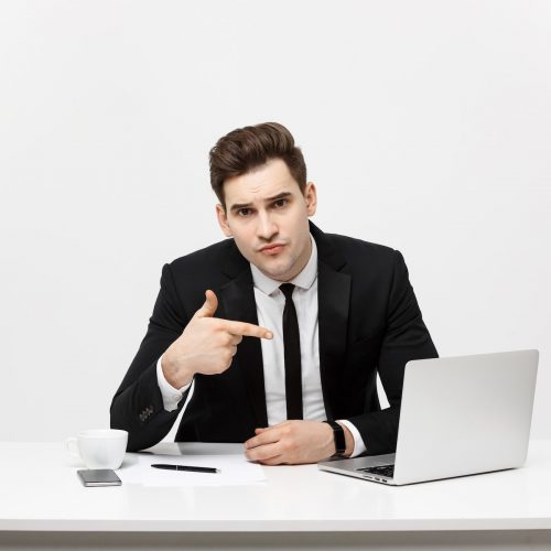 businessman-sitting-desk-point-finger-isolated-laptop-screen-handsome-young-business-man-look_1258-80620